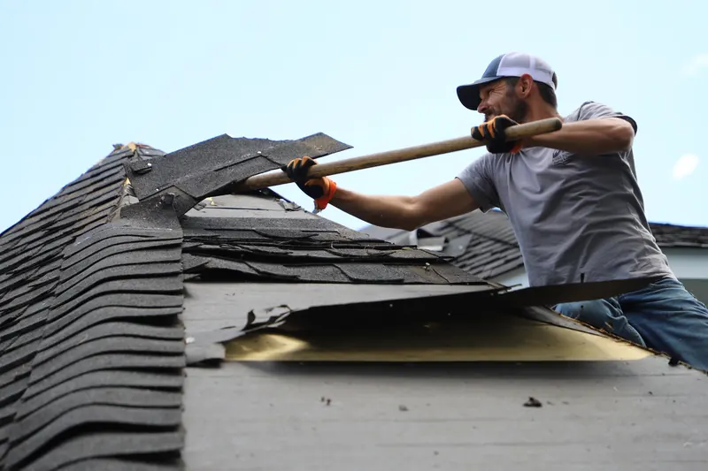 Ridge Runners roofer removing old shingles from a roof
